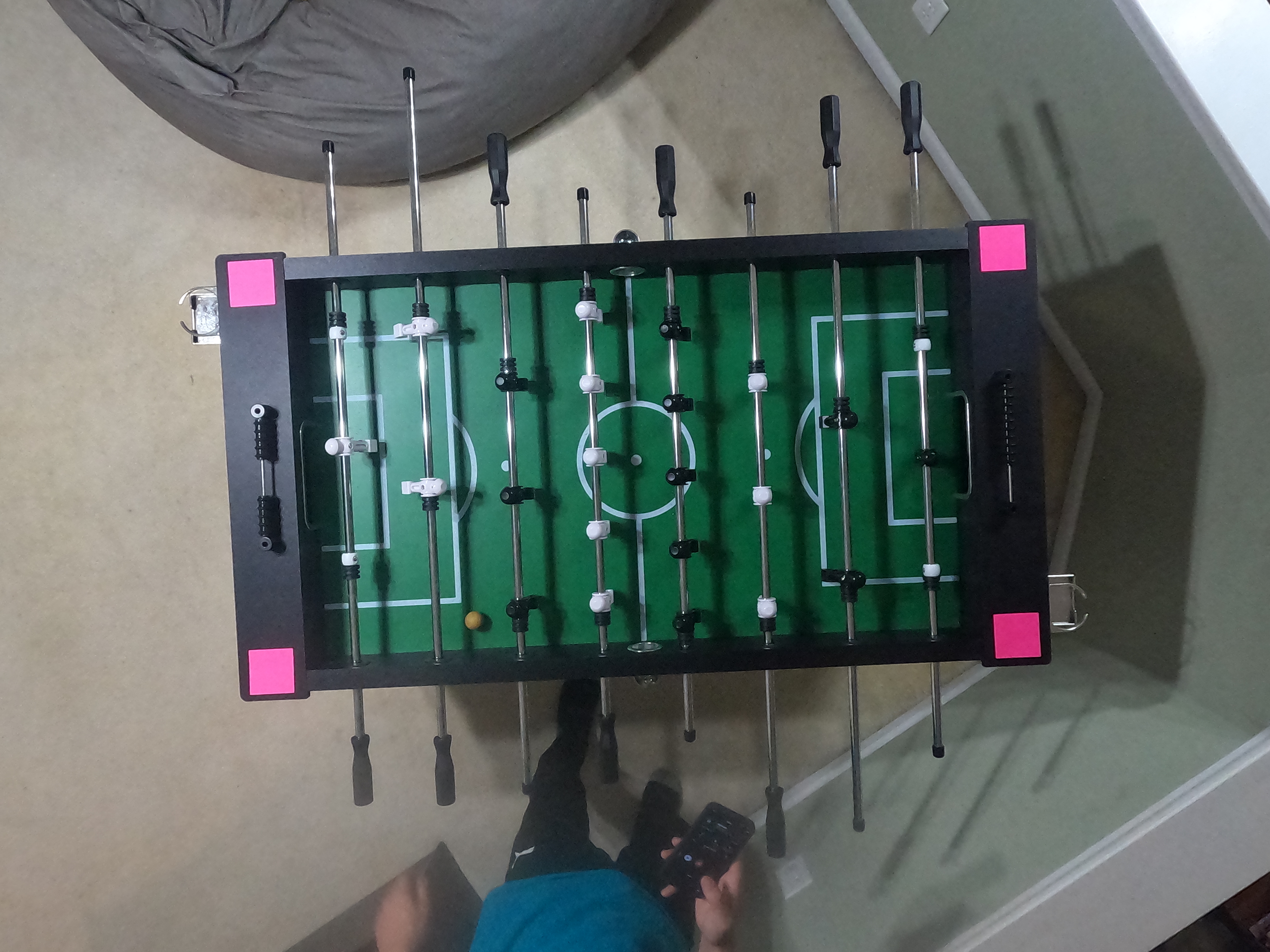 Foosball table setup with pink sticky notes for auto-crop